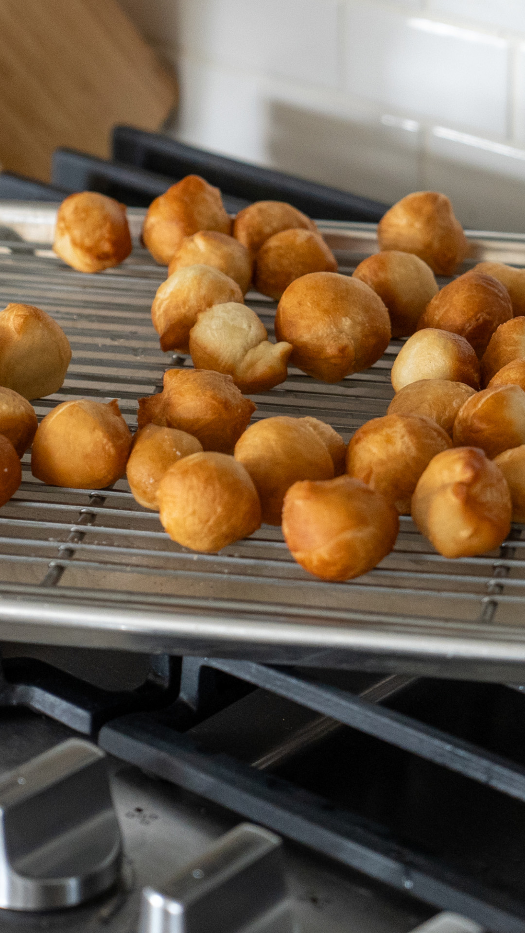 Donut holes draining on cooling rack.