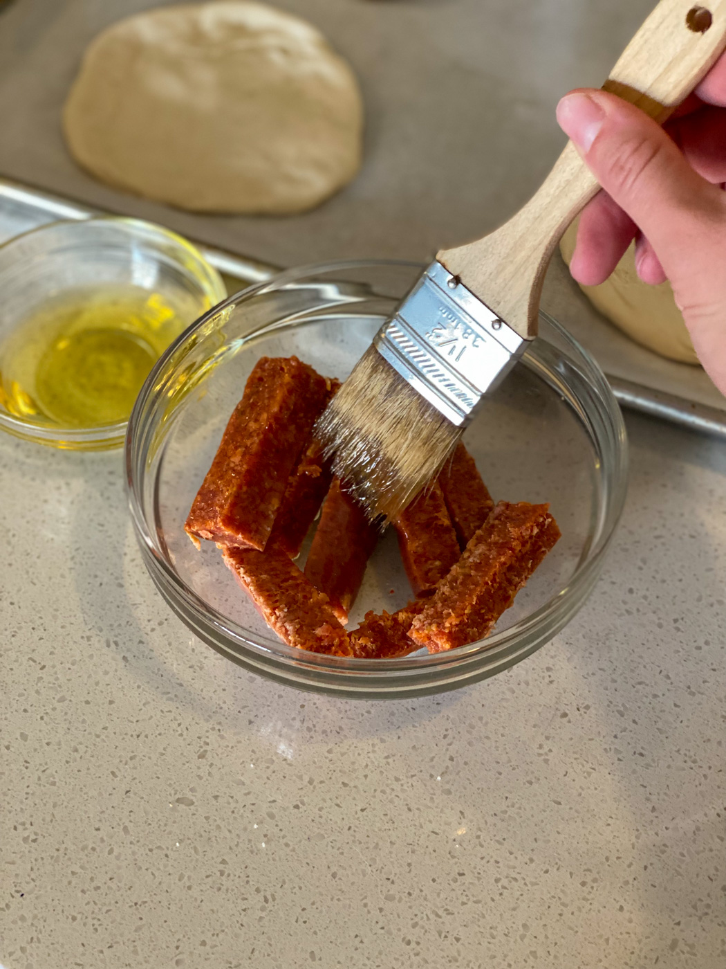 Brush pepperoni with olive oil.