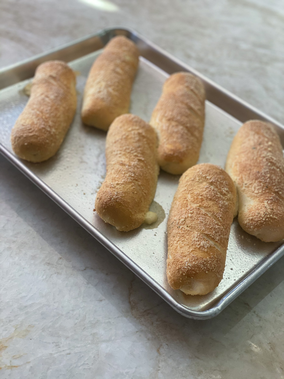 Baked giant cheesy breadsticks.