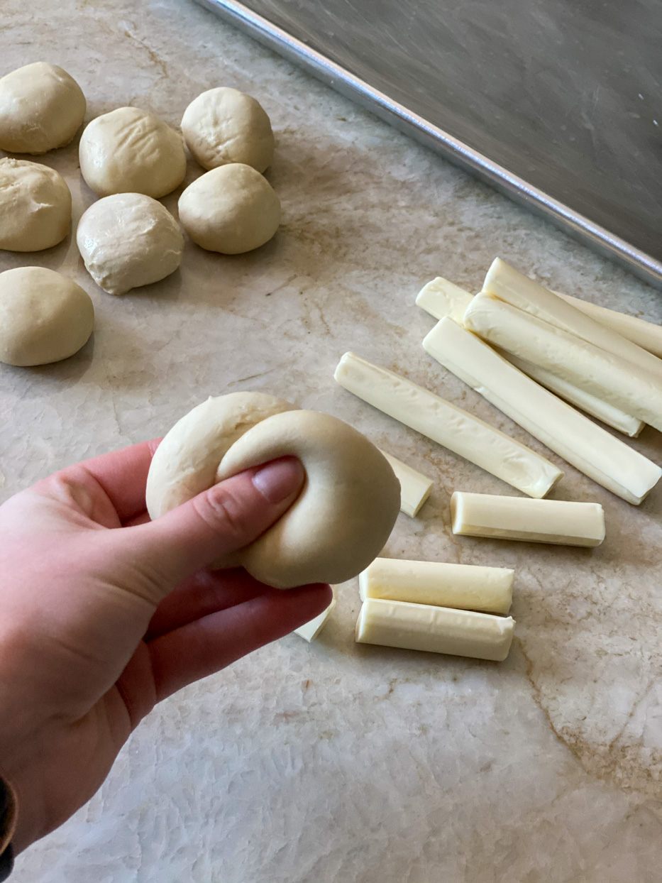 Combining two rolls with cheese sticks in the background.