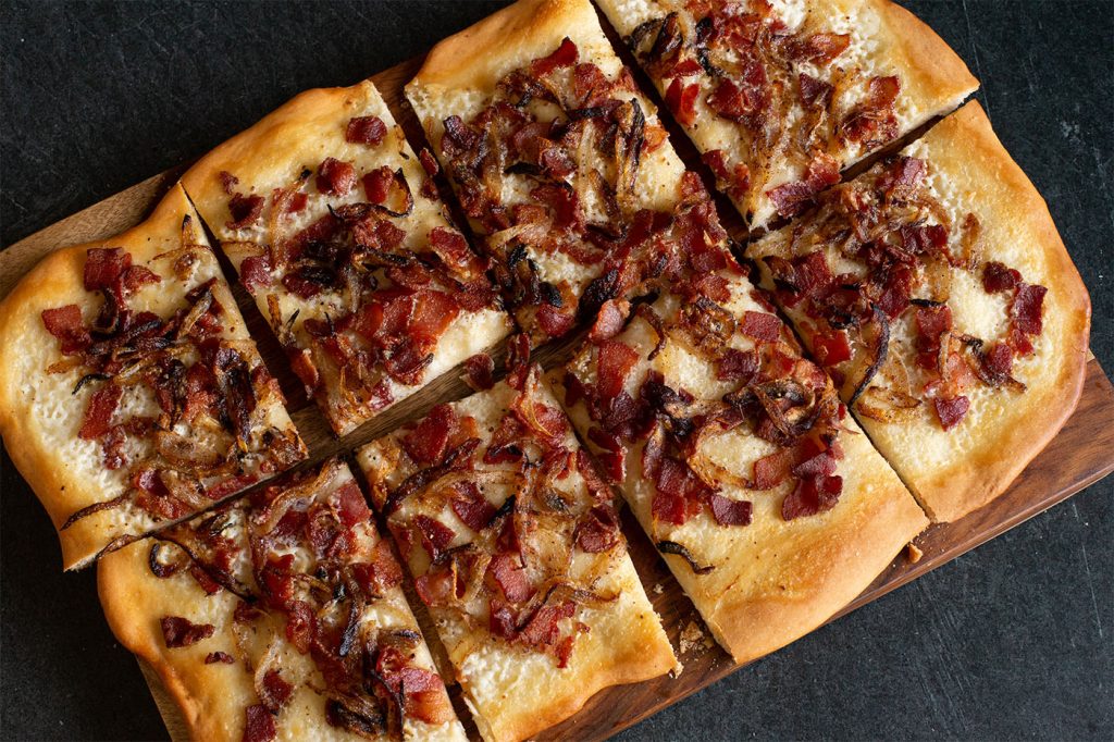 Bacon, creme fraiche and onions top this flatbread to recreate this traditional German pizza.