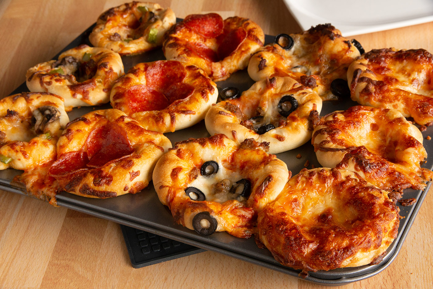 Mini deep dish pizzas in a muffin tin.