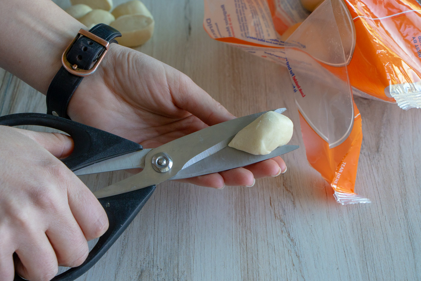 Dinner Roll dough being cut in half.