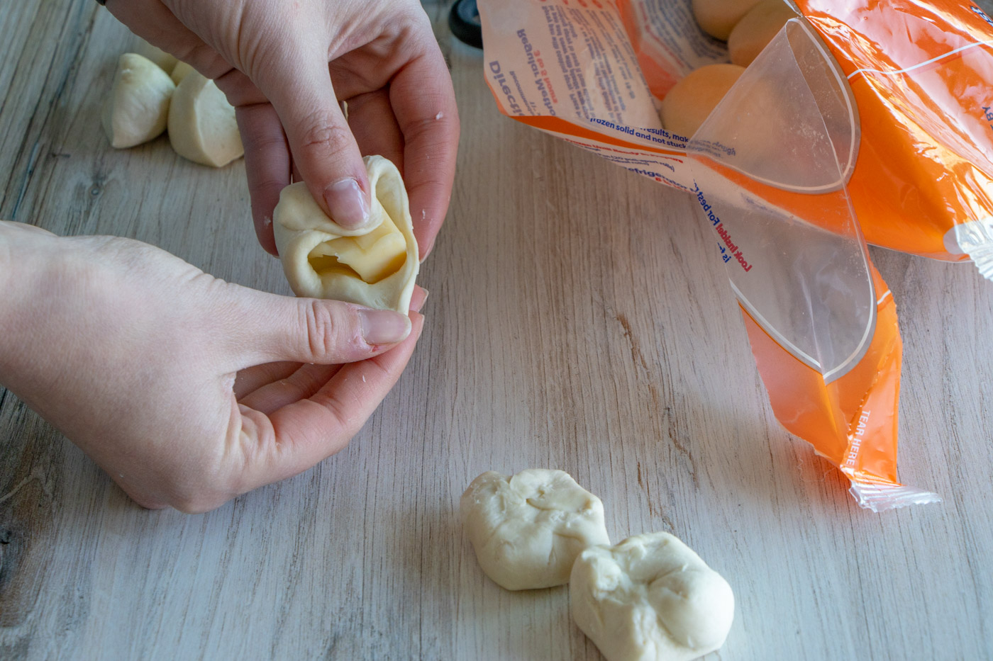 Wrapping dough around cheese.