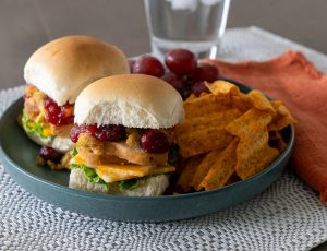 Leftover Sliders on a plate with chips and grapes.