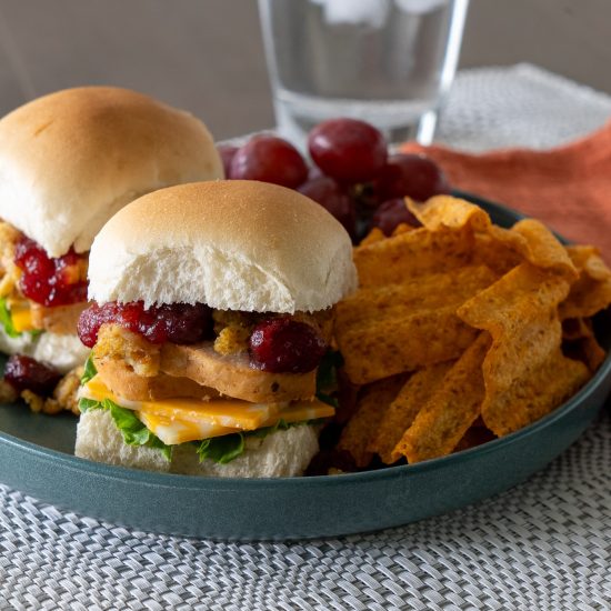 Leftover Sliders on a plate with chips and grapes.
